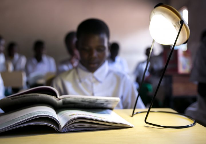 Lampa lyser upp en bok på ett skrivbord